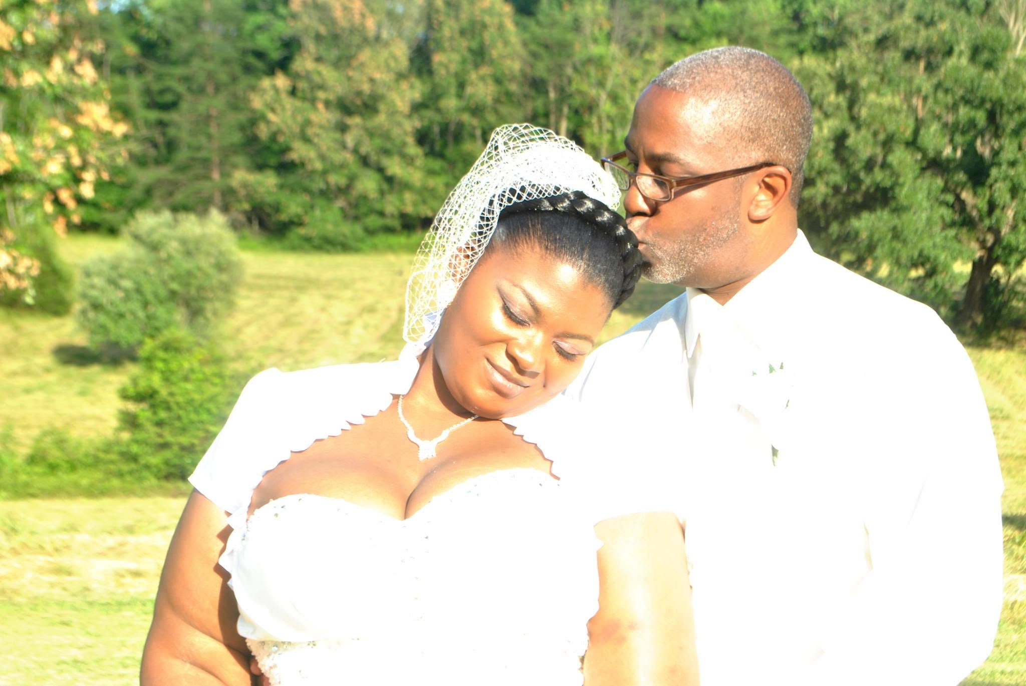 A groom kissing his bride during their outdoor wedding portraits
