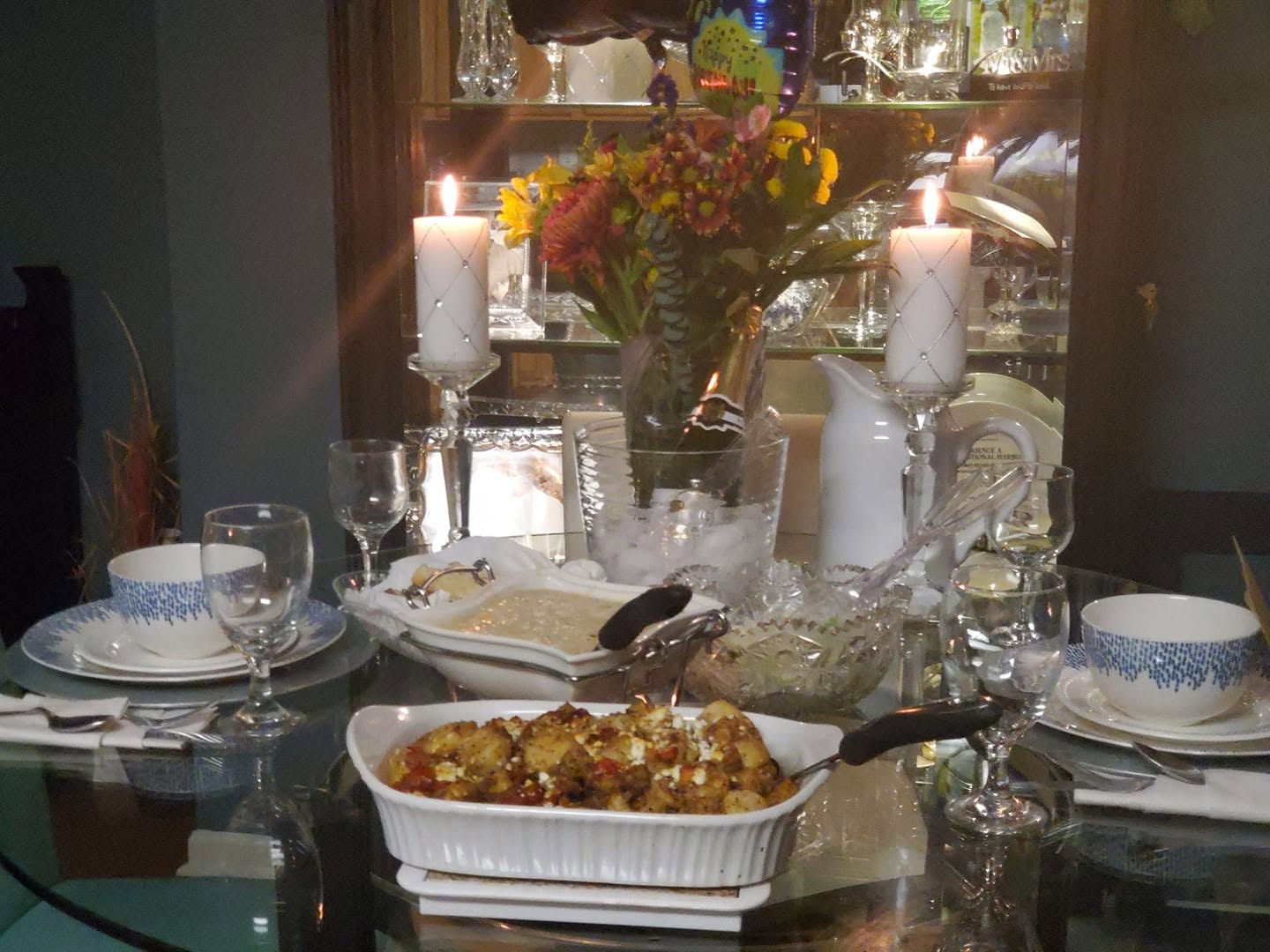 An intimate candlelit private dinner table with flowers and a freshly prepared meal